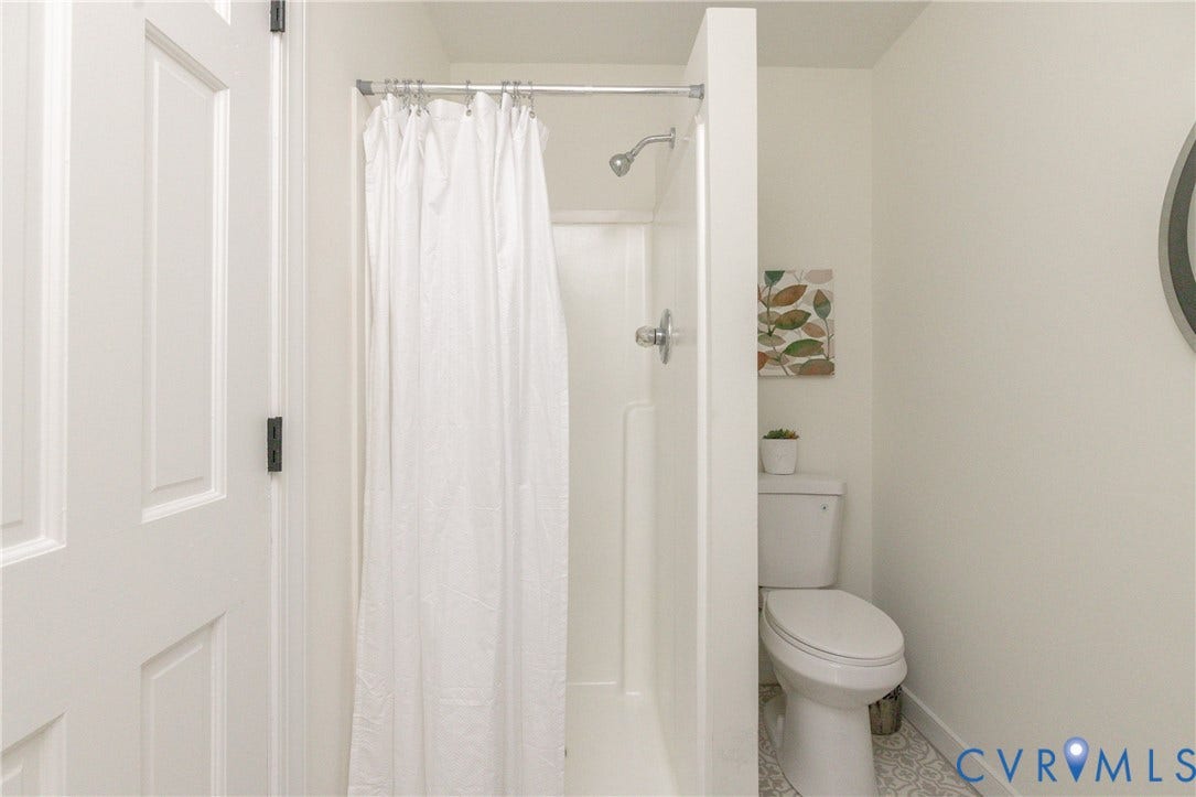 Shower with chrome fixtures and a white paneled door