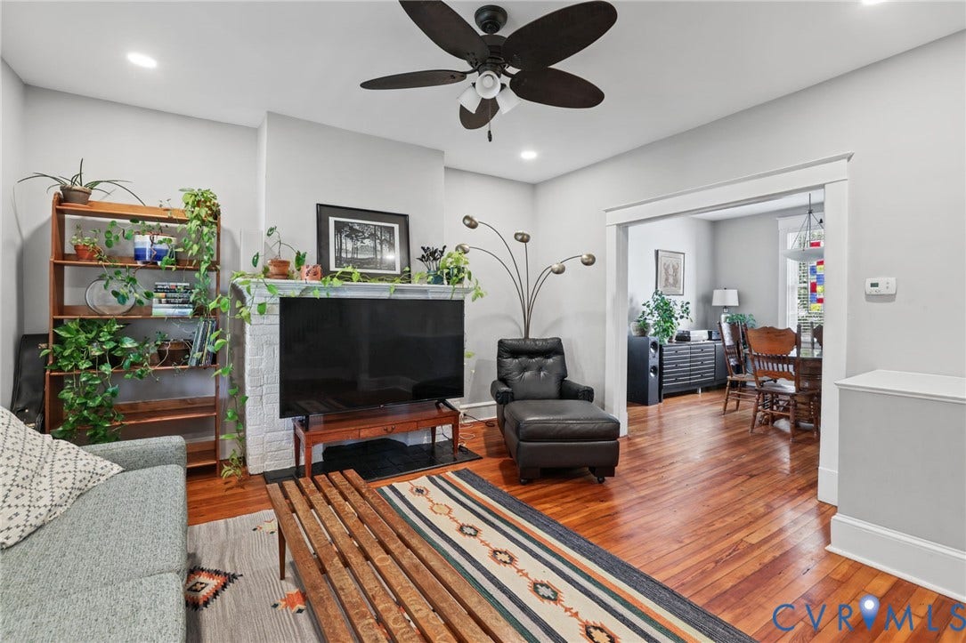Hardwood flooring, painted brick fireplace, recessed lighting, ceiling fan, and cased opening