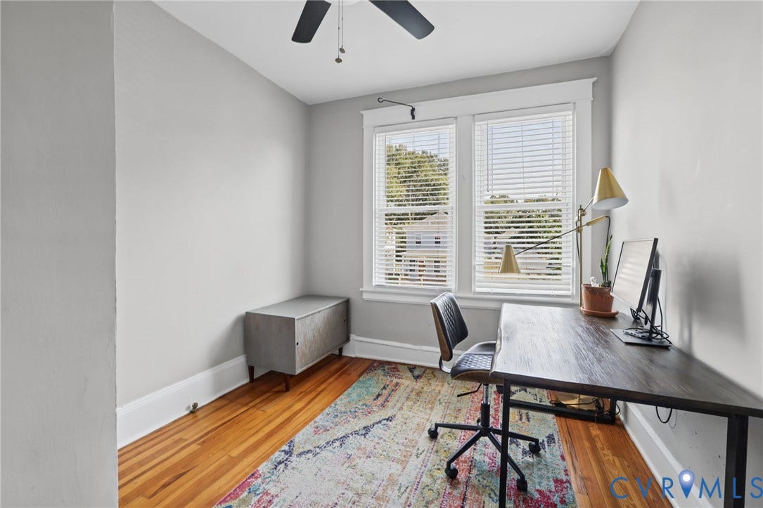 Hardwood flooring, painted walls, dual windows with blinds, and a ceiling fan