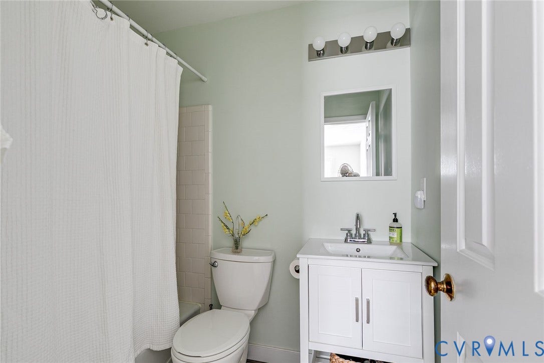 Tub and shower, fresh tile and white vanity