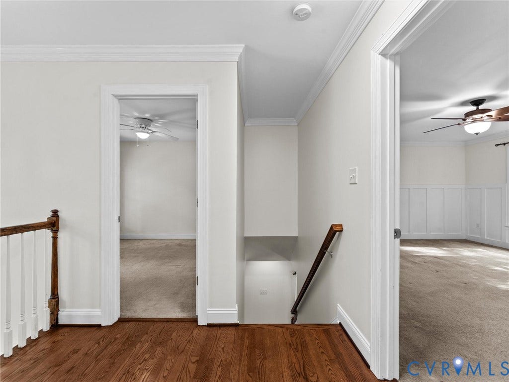 Wood-finish flooring, white trim, and crown molding