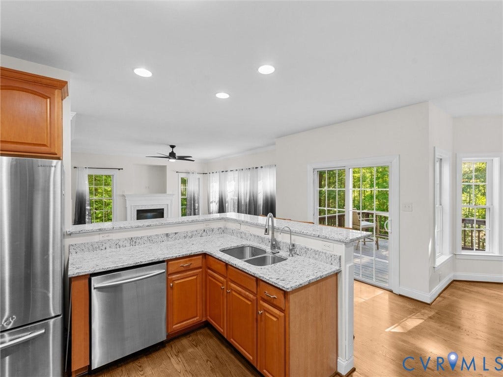 Kitchen featuring wood cabinetry, stainless steel appliances, and stone countertops