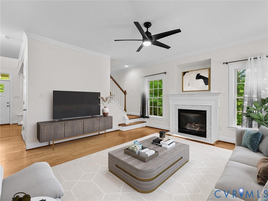 Living area featuring a fireplace with a decorative mantel, hardwood flooring, and a contemporary ceiling fan