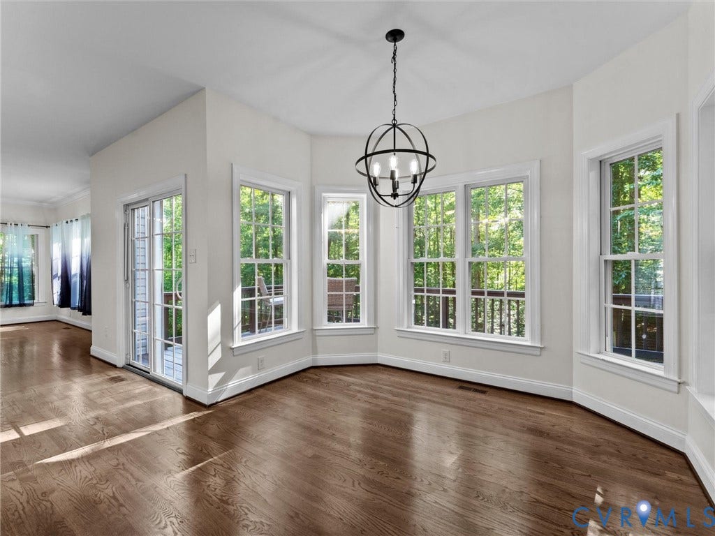 Wood-finish flooring throughout, bay windows, and a sliding glass door