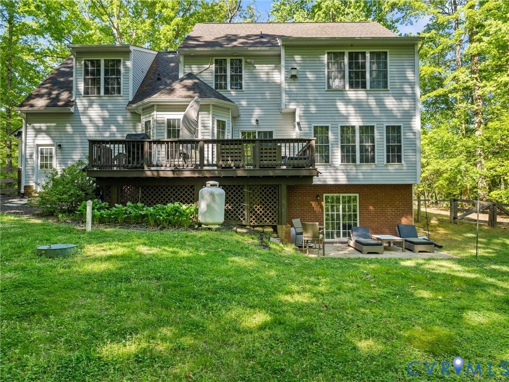 Rear elevation featuring a multi-level deck, lower patio, and a walk-out basement