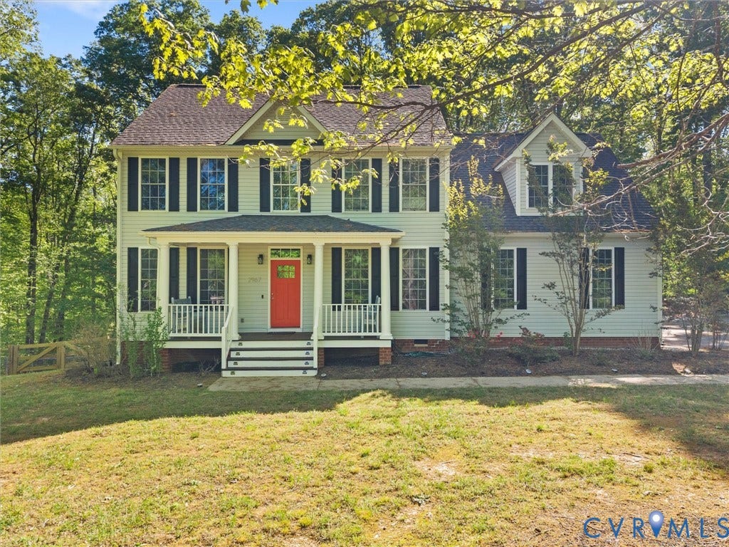 Two-story colonial exterior with light-colored siding, a covered porch, and a bright red front door