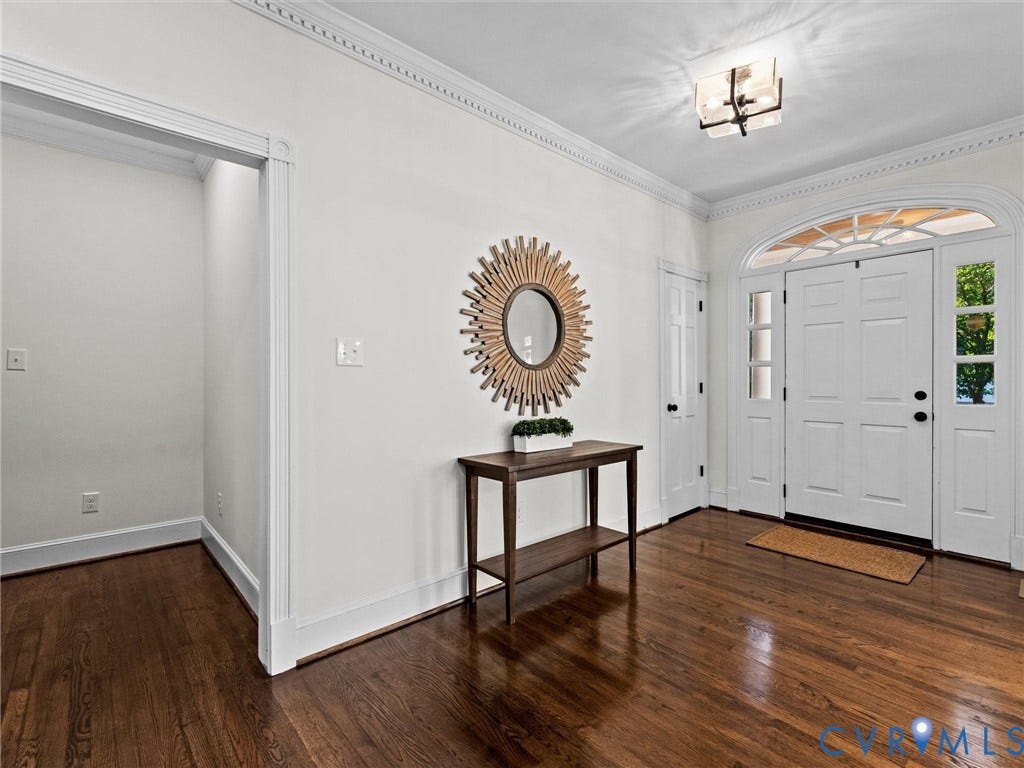 Hardwood flooring, crown molding, double front doors with transom window, sidelights, and overhead lighting