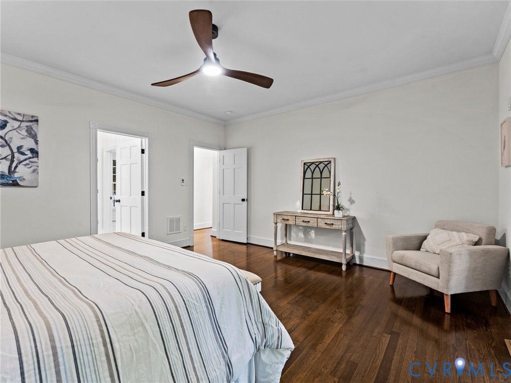 Hardwood flooring, crown molding, white paneled doors, and a ceiling fan with integrated lighting