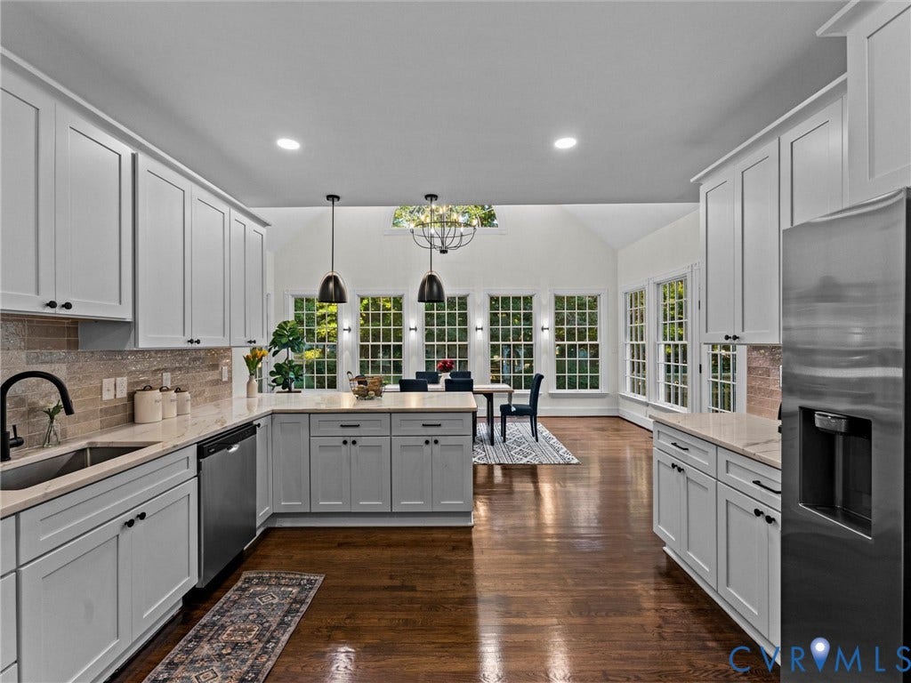 Kitchen featuring light-toned cabinetry, light-toned countertops, a stainless steel sink, and stainless steel appliances