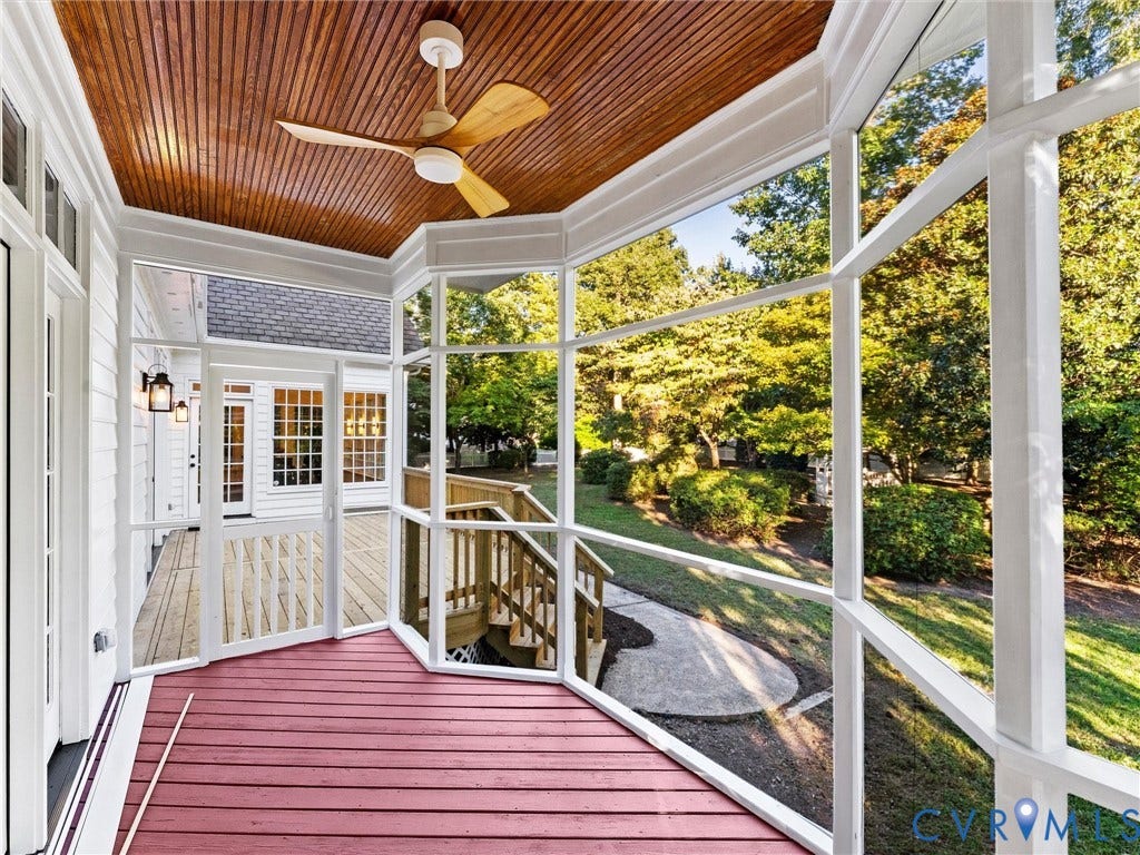 Screened porch featuring a wood-finish ceiling, ceiling fan, and red-stained flooring