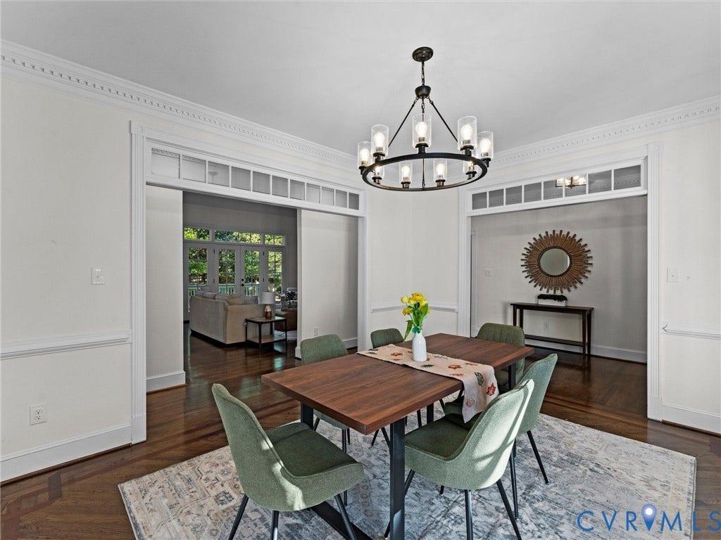 Dark wood-finish flooring, elegant crown molding, and wainscoting details