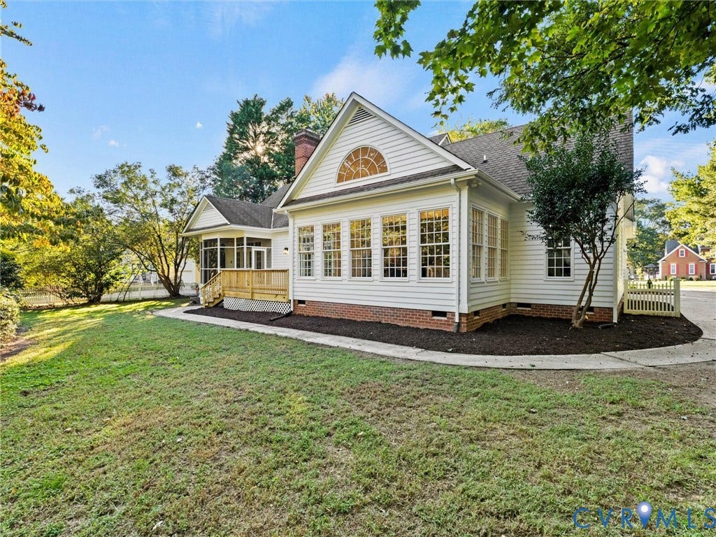 White siding exterior with a brick foundation, a sunroom with multiple windows, a screened porch, and a wooden deck