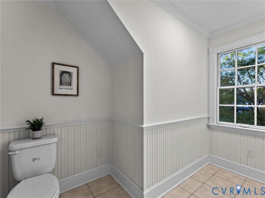 Tile flooring, beadboard wainscoting, crown molding, and a window with grid detailing