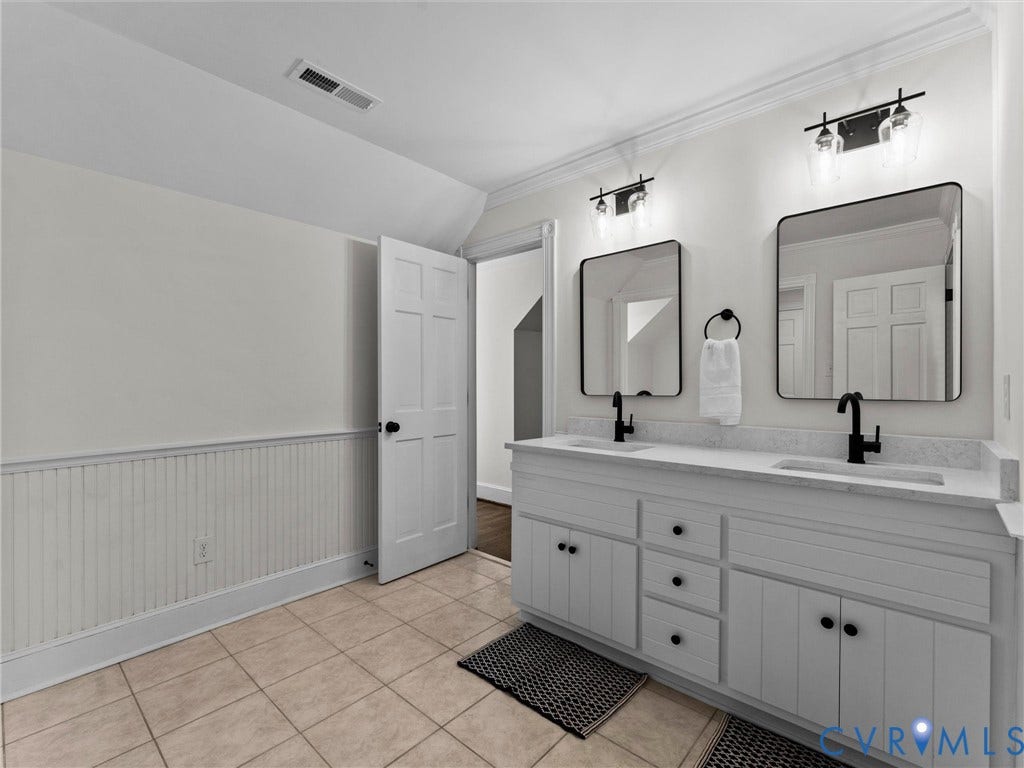 Dual vanity with white cabinetry, matte black hardware, and quartz countertops