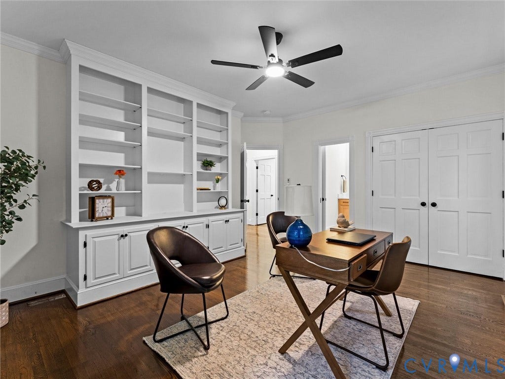 Built-in shelving with lower cabinetry, wood-finish flooring, two panel doors, and a ceiling fan with integrated lighting
