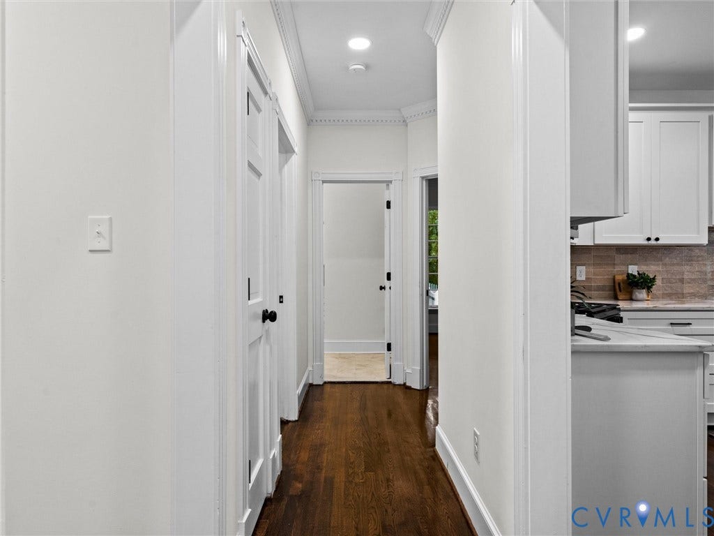 Hallway with dark wood-finish flooring, recessed lighting, and crown molding