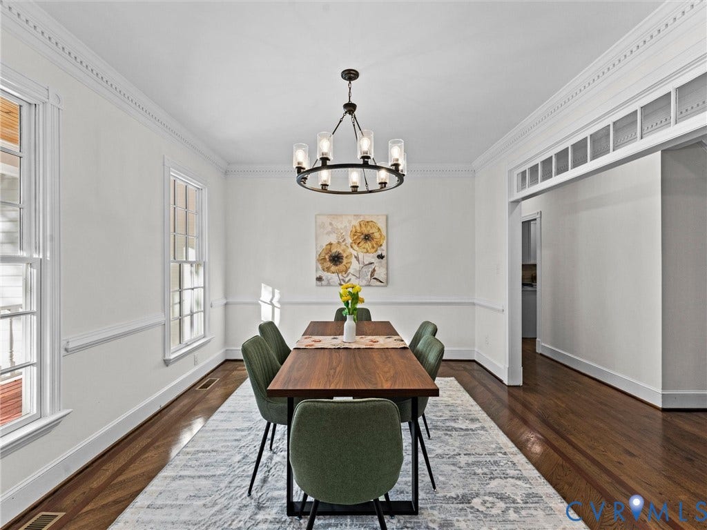 Dining area with wood-finish flooring and crown molding