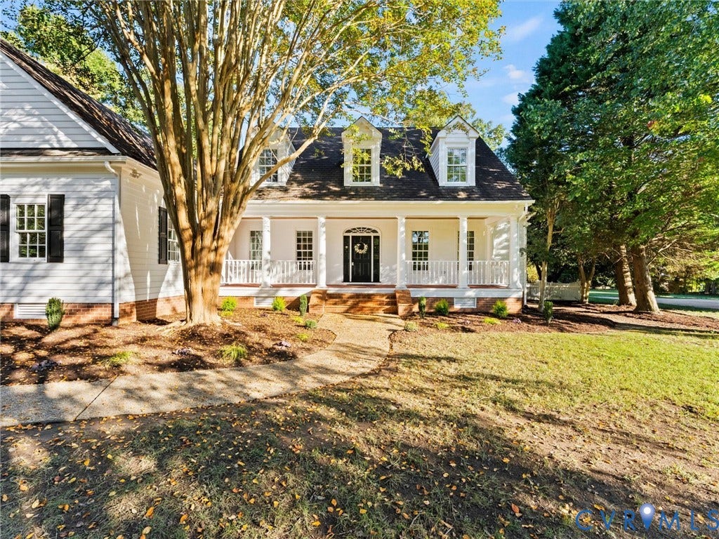 White siding exterior with a covered front porch featuring white columns and railing