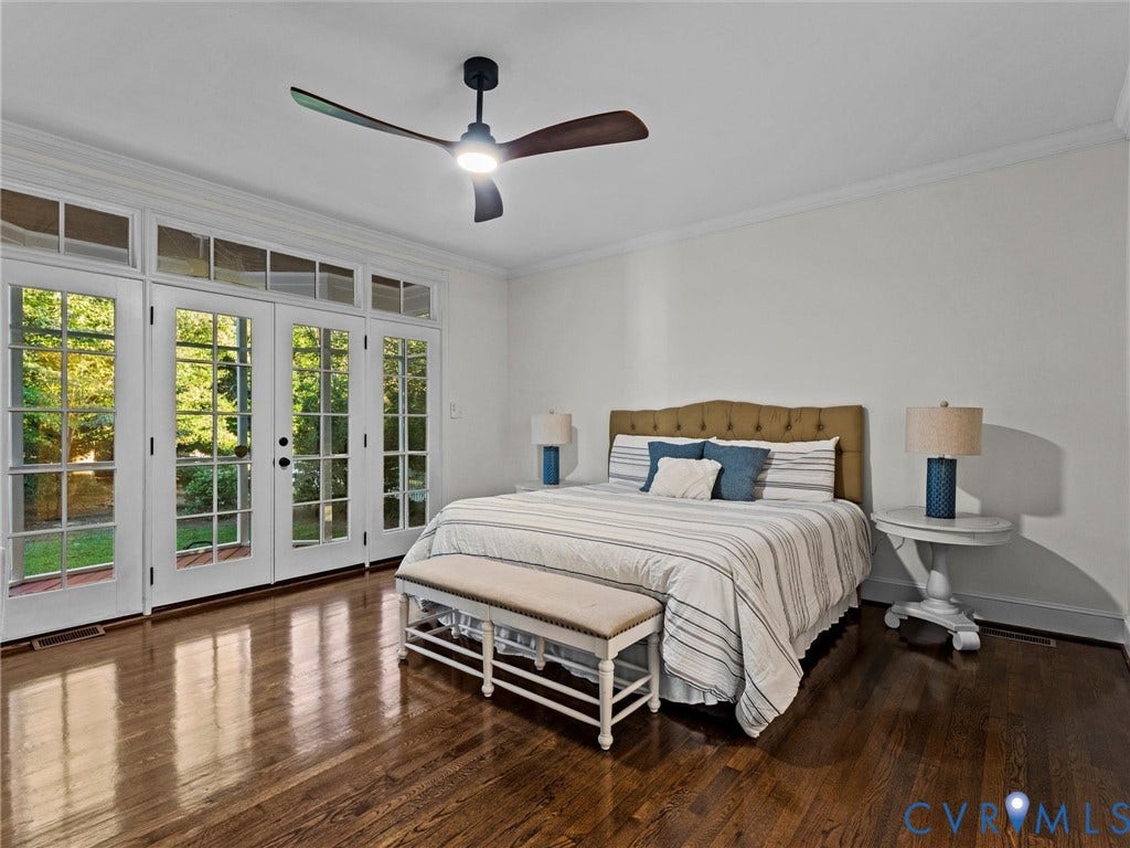 Hardwood flooring, crown molding, double French doors, transom windows, and a ceiling fan with integrated lighting
