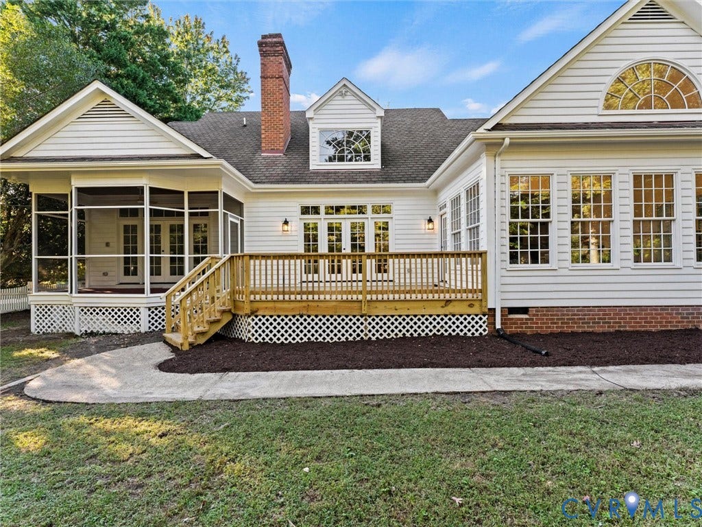Exterior featuring white siding, a screened porch, a wood deck with railings, and a brick foundation