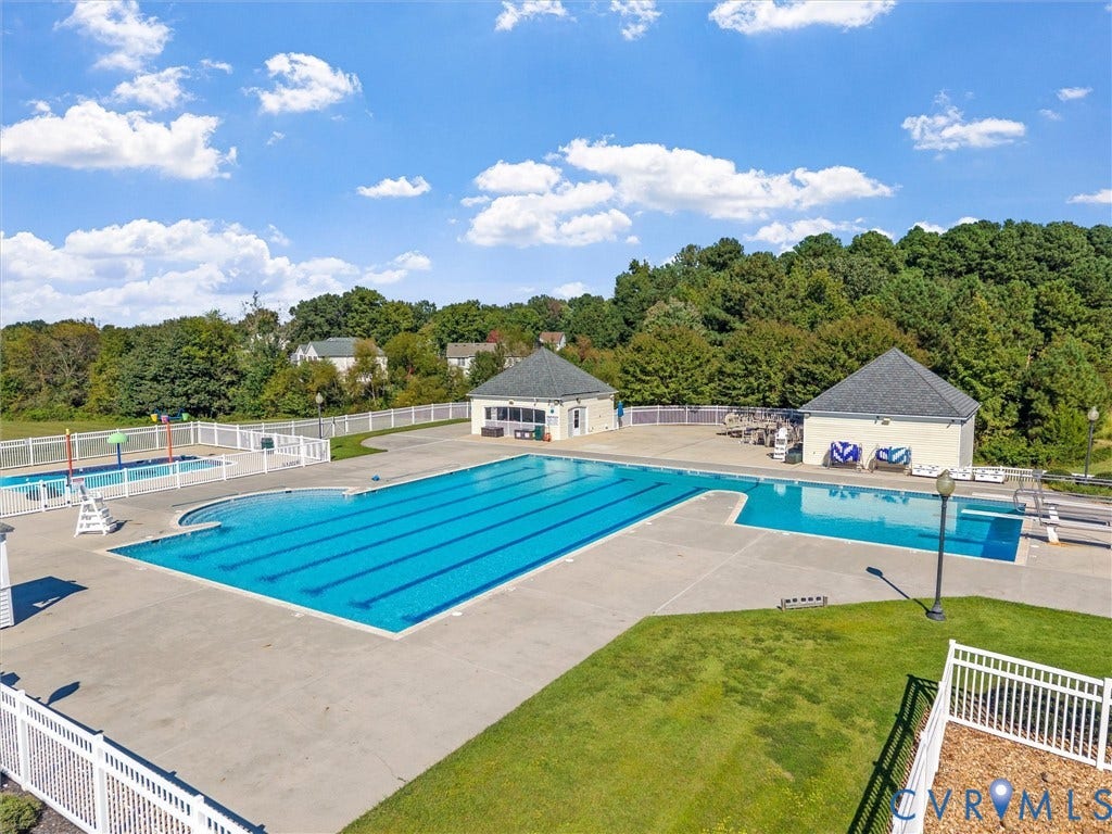 Community pool area featuring a multi-lane lap pool, a separate recreation pool, and an additional shallow pool