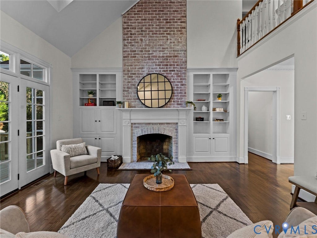 Vaulted ceiling with a brick-clad fireplace and wood mantel