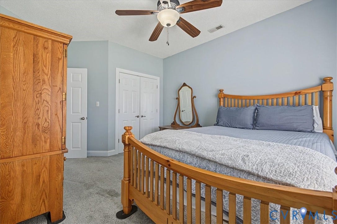Vaulted ceiling featuring a ceiling fan with integrated lighting, wall-to-wall carpeting, and dual-panel interior doors