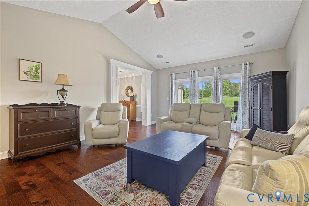 Vaulted ceilings, wood-finish flooring, recessed lighting, and large windows with casing trim