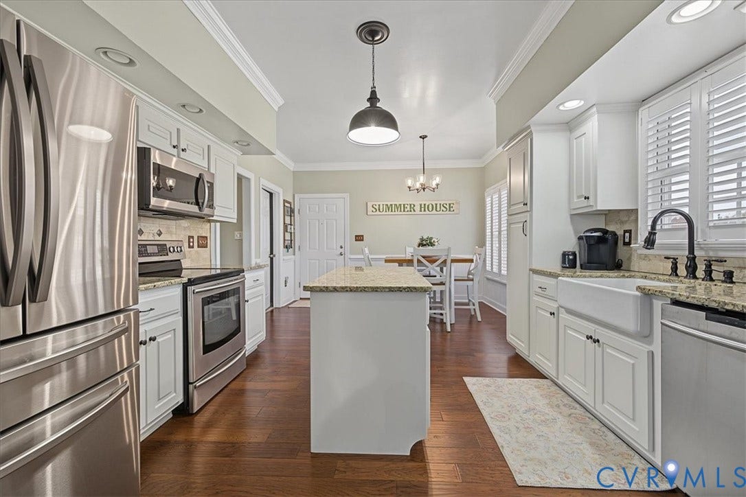 Kitchen featuring white cabinetry, stone countertops, farmhouse sink, stainless steel appliances, and wood-finish flooring