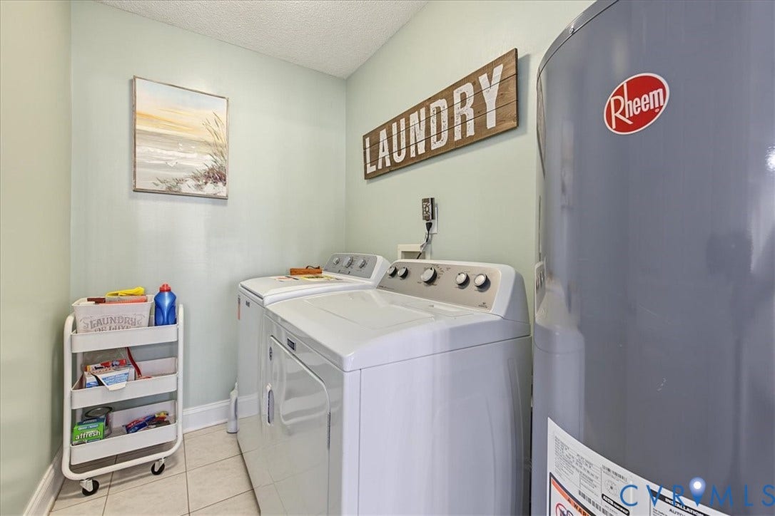 Utility area featuring a top-load washing machine, a front-load dryer, and a tall cylindrical water heater finished in grey