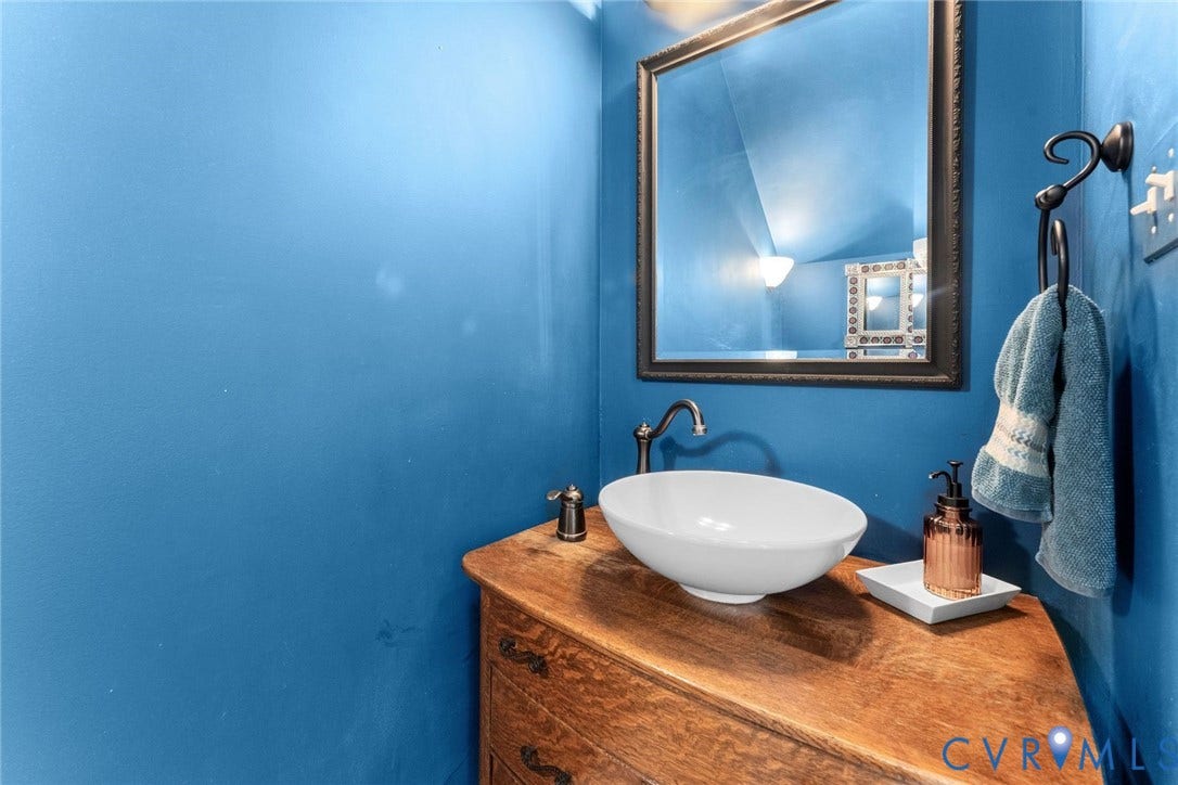 606 Westham Woods Drive, Tuckahoe, Henrico, VA 23229 Wood-finish vanity with an integrated vessel sink and a wall-mounted mirror