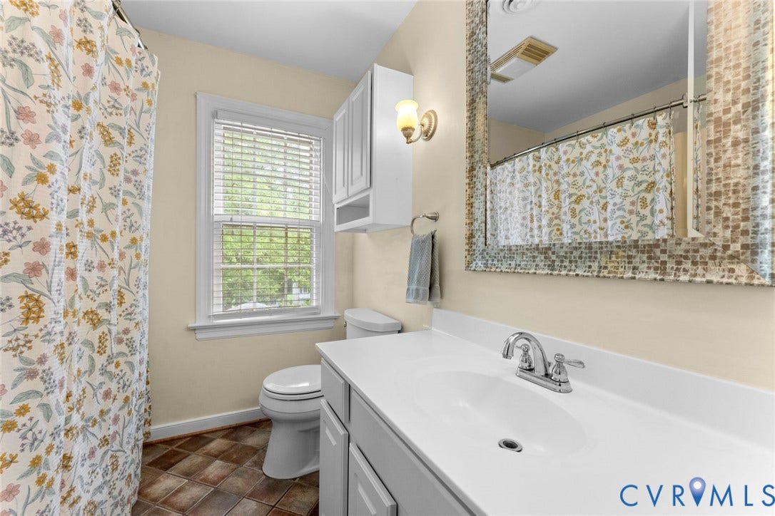 606 Westham Woods Drive, Tuckahoe, Henrico, VA 23229 White vanity with integrated sink, chrome faucet, wall-mounted sconce, and framed mirror