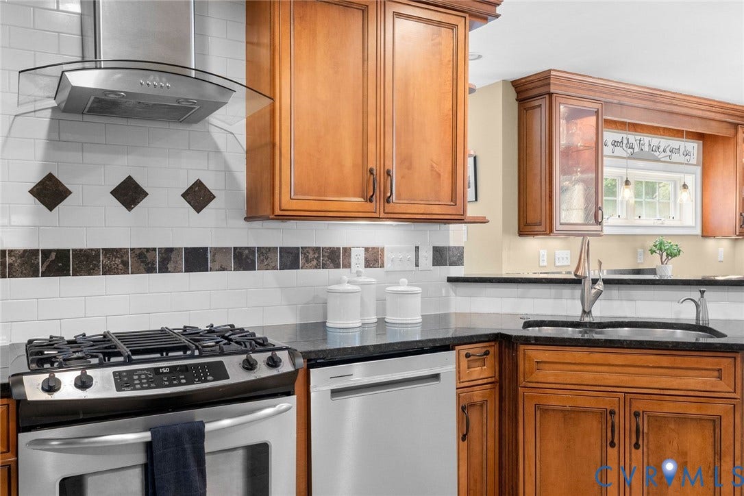 606 Westham Woods Drive, Tuckahoe, Henrico, VA 23229 Stainless steel gas range, coordinating dishwasher, and a curved glass range hood
