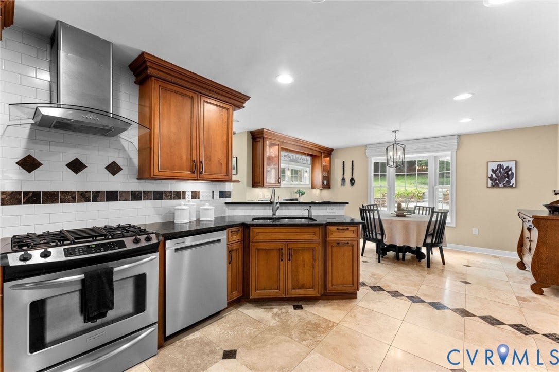 606 Westham Woods Drive, Tuckahoe, Henrico, VA 23229 Stainless steel appliances, wood-finish cabinetry, black countertops, white subway tile backsplash with decorative accents, and tiled flooring with dark square inserts