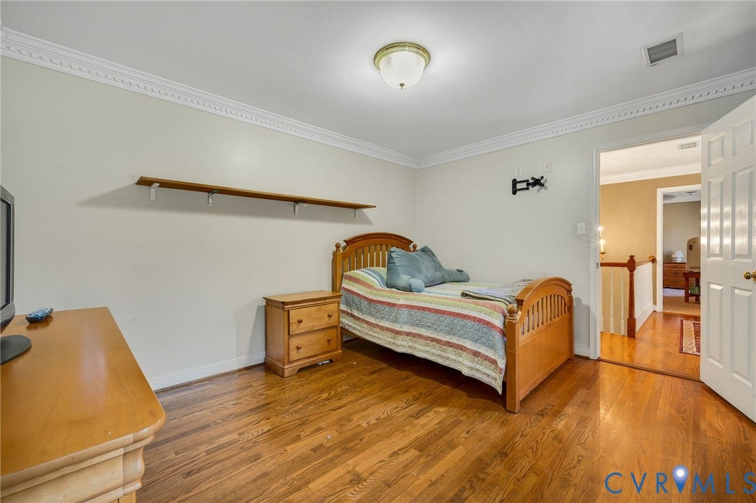 Hardwood flooring throughout, crown molding, and a built-in wall shelf
