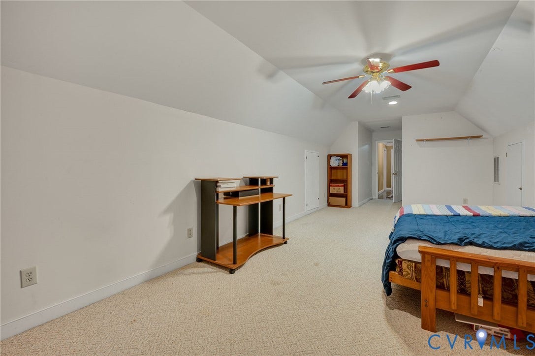 Carpeted room with sloped ceilings, ceiling fan, and recessed lighting
