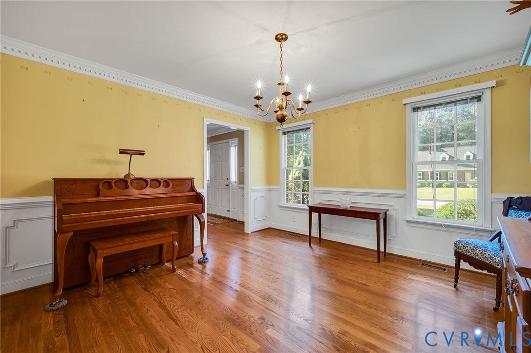 Hardwood flooring, crown molding, chair rail, and multiple windows