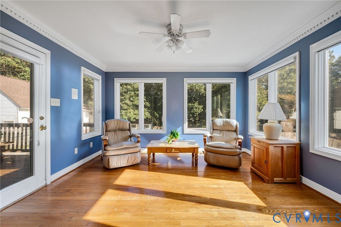 Hardwood flooring, multiple windows, ceiling fan, crown molding, and a white-framed glass paneled door