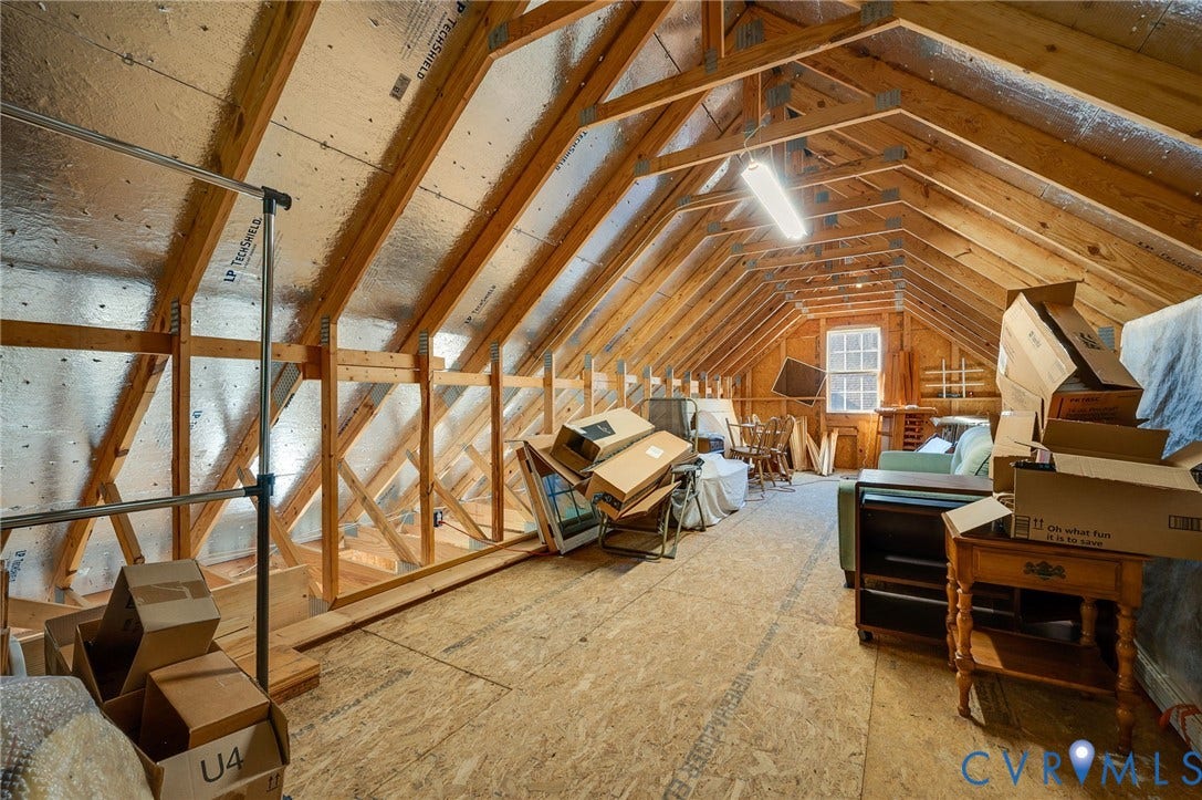 Exposed wood beam construction, insulated attic space, wood-finish flooring, and a double-hung window