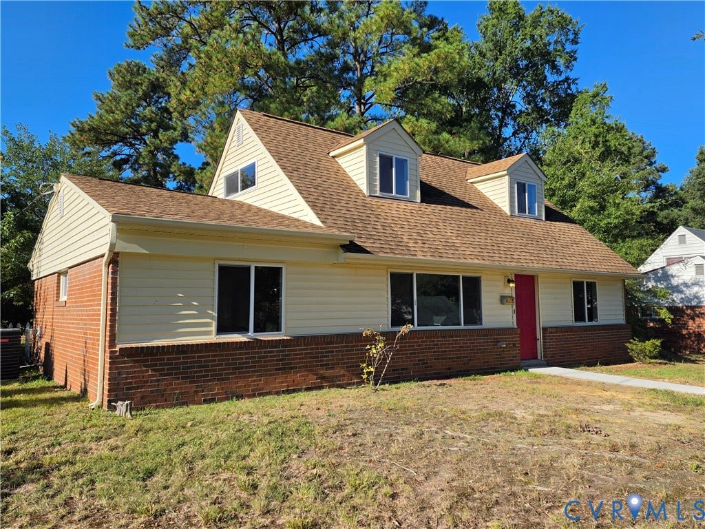 Two-story residence featuring brick and siding exterior, a gabled roof, and multiple dormer windows