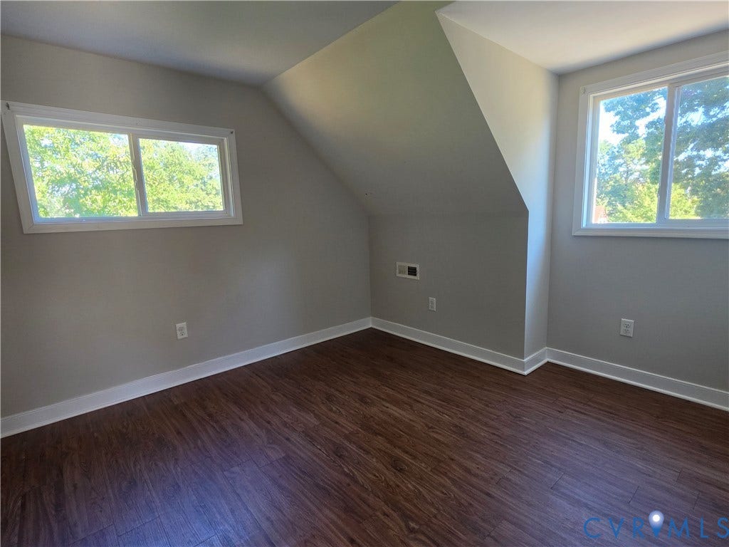 Wood-finish flooring with white trim, complemented by light gray walls