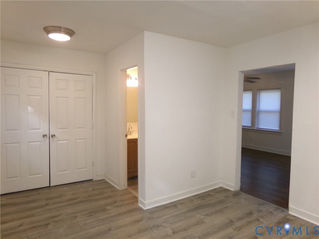 Wood-finish flooring throughout, white walls, and a recessed ceiling light