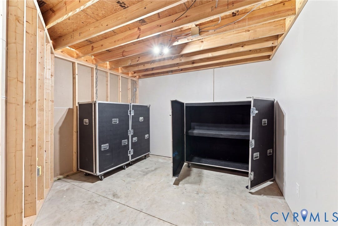 Unfinished basement with exposed wood framing, concrete flooring, and exposed ceiling joists