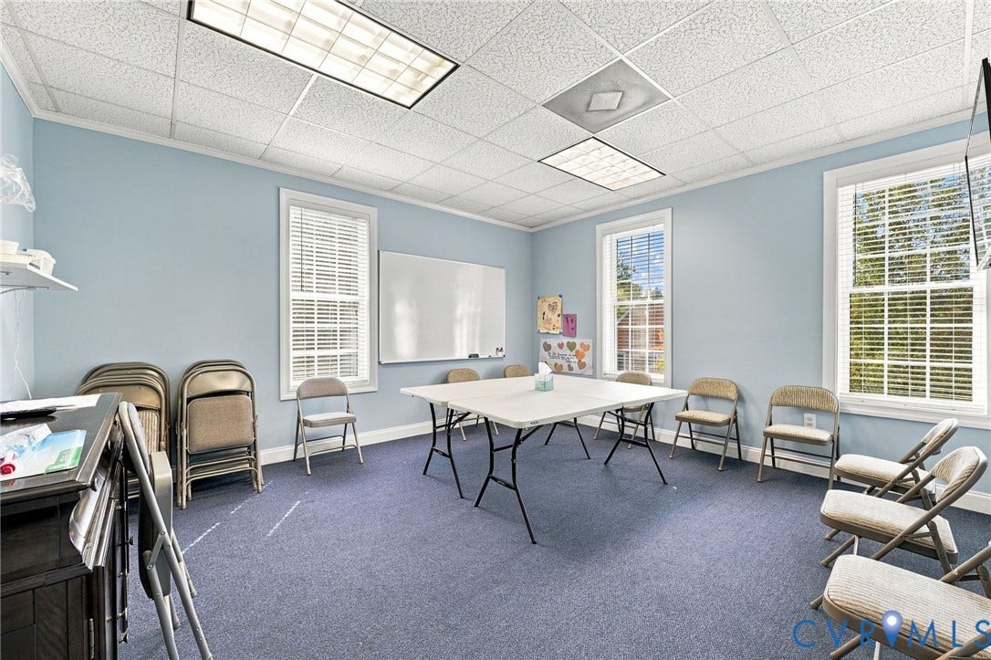 Light blue walls with white trim, multiple windows with blinds, recessed lighting, and a drop ceiling