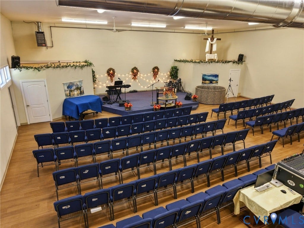 Spacious interior with wood-finish flooring, elevated platform, and exposed overhead ductwork