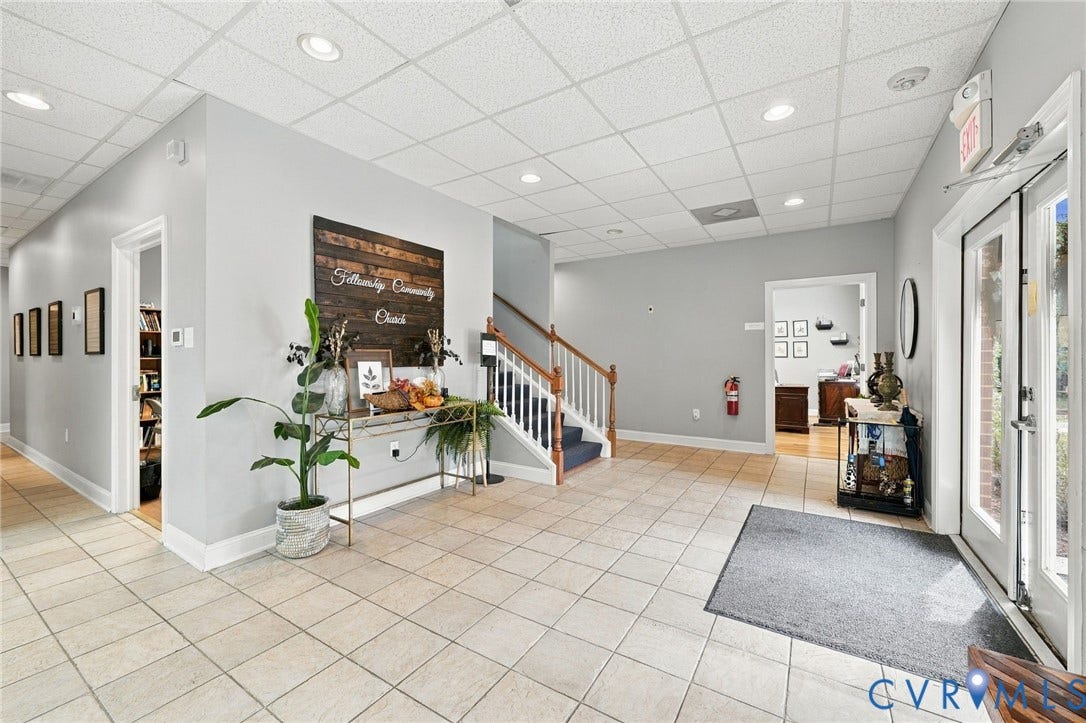 Tile flooring, recessed lighting, white trim, wood-finish accent wall, and a staircase with white balusters