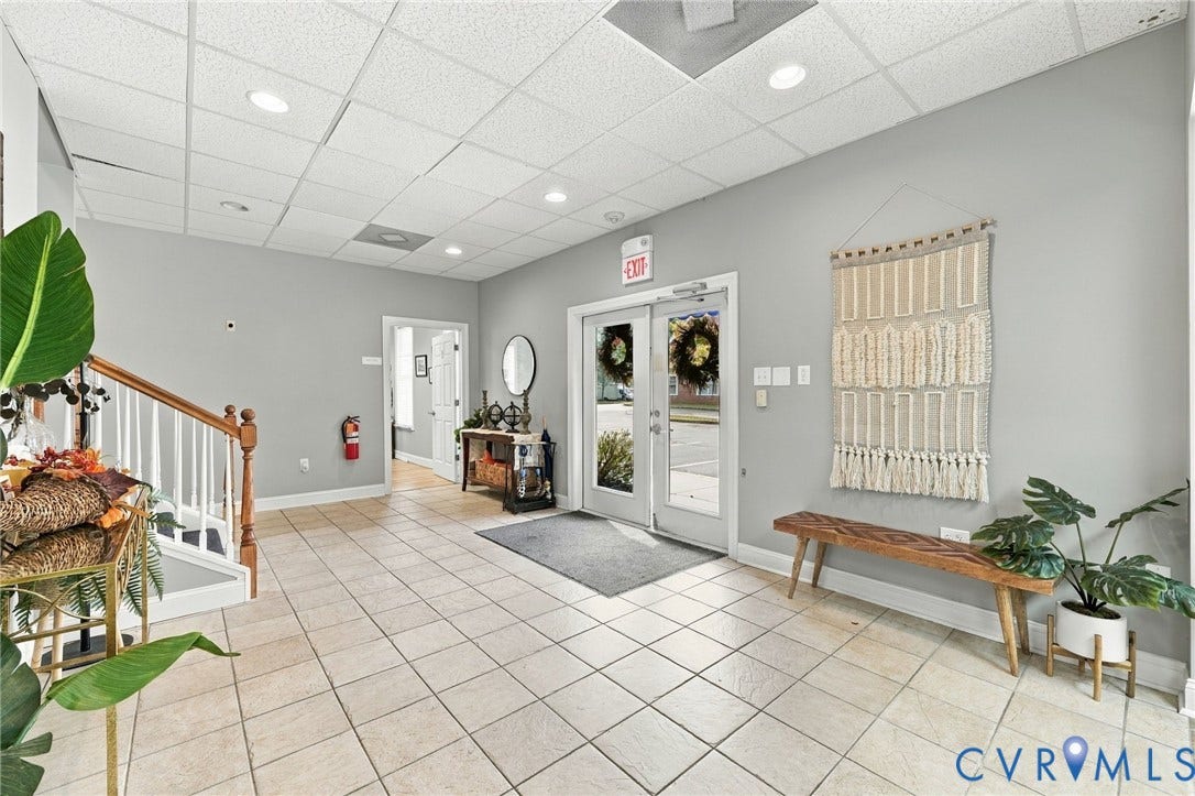 Tile flooring with light gray walls, recessed lighting, and a wood banister