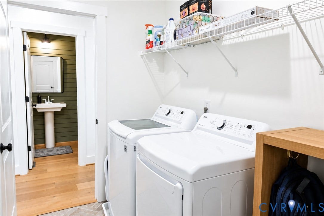 6265 Bushnell Drive, Rochambeau Estates, New Kent, VA 23124 Laundry area featuring white appliances, a wire shelving system, and a wooden storage unit