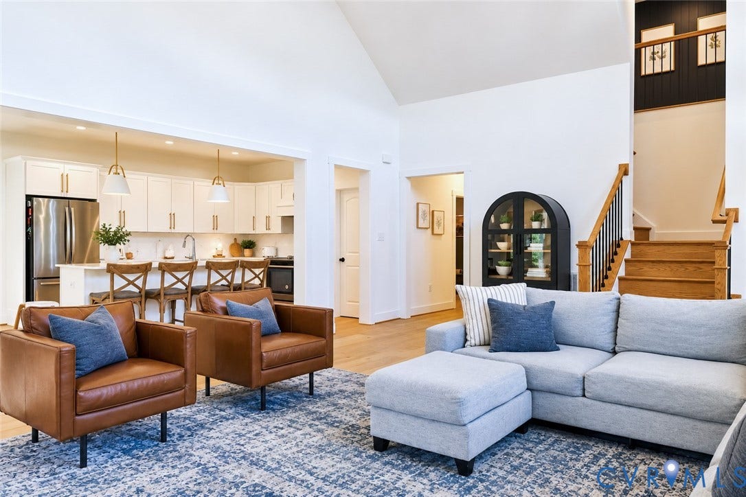 6265 Bushnell Drive, Rochambeau Estates, New Kent, VA 23124 Vaulted ceilings, wood-finish flooring, white cabinetry with gold-tone hardware, stainless steel appliances, and a wood staircase with black balusters