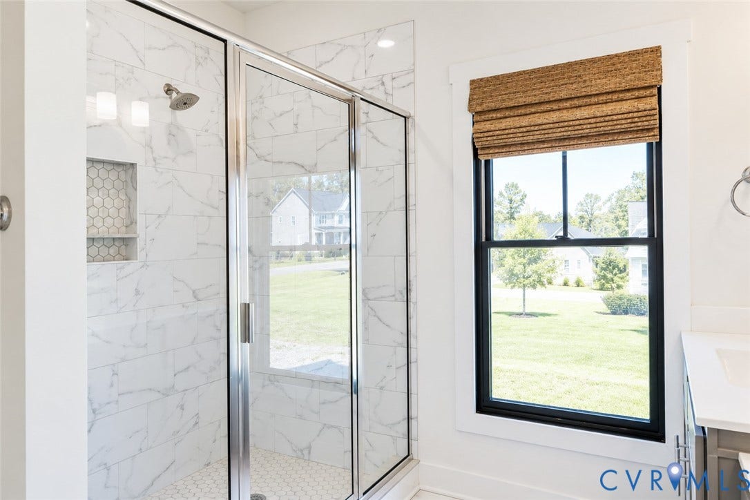 6265 Bushnell Drive, Rochambeau Estates, New Kent, VA 23124 Shower with marble-patterned tile, glass enclosure, and hexagonal tile accents